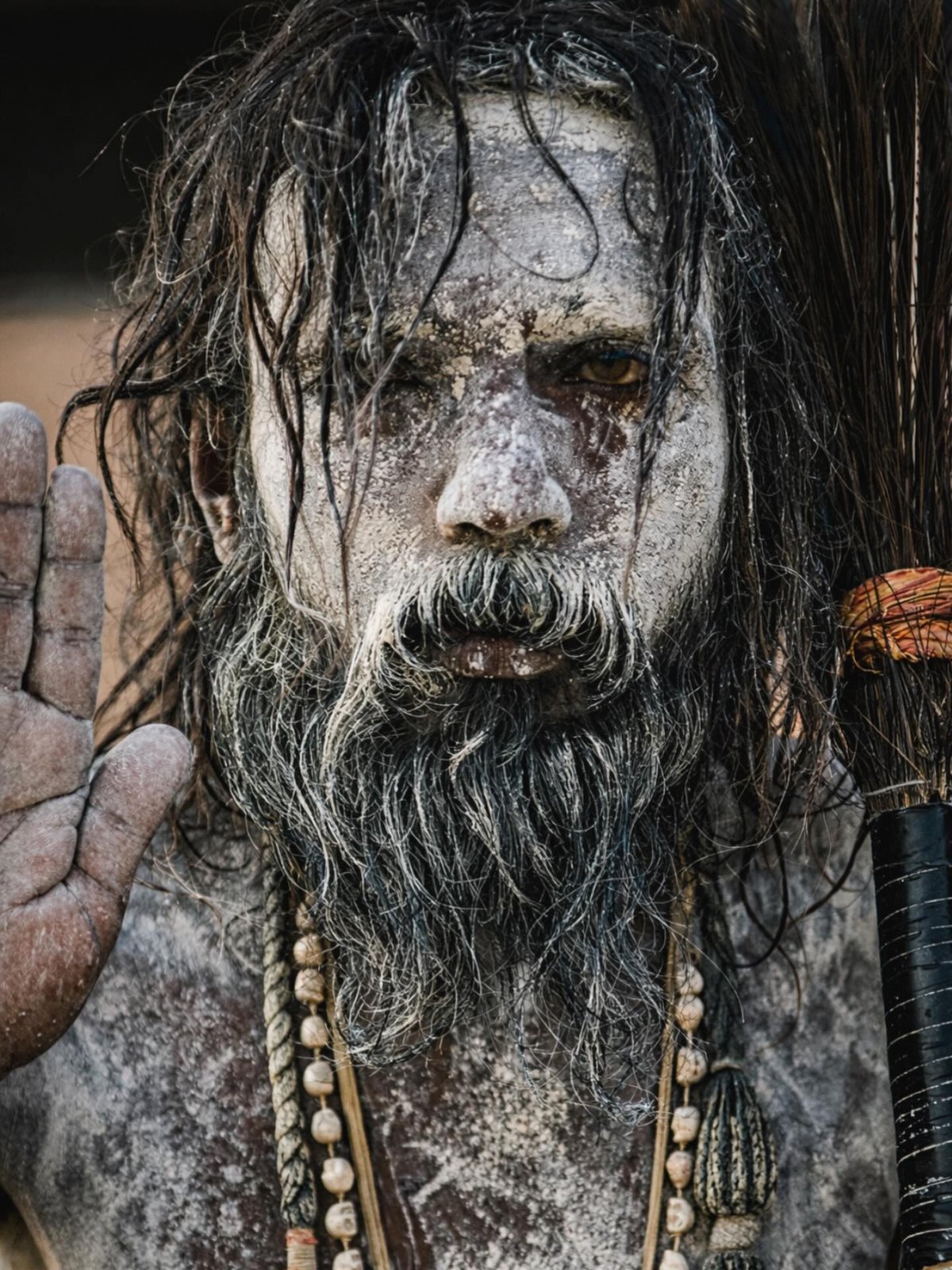 An ash-covered holy man on the banks of the Ganges staring straight into the lens, unflinching.