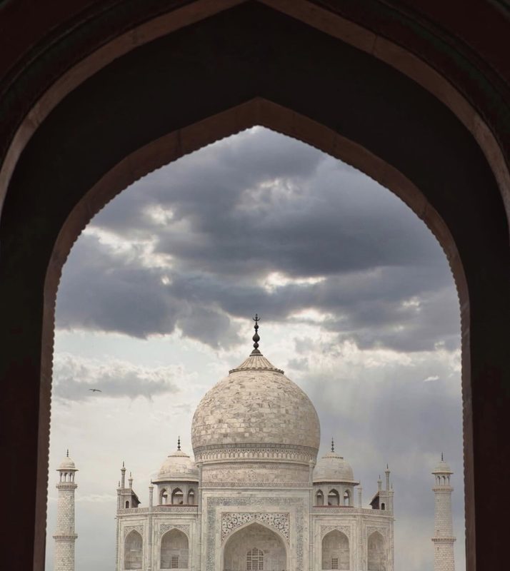 The Taj Mahal seen through a great arch, the imagined place and the arrived-at place in one frame.