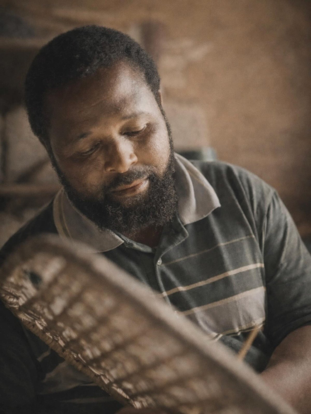 A craftsman at work in Africa, photographed after a walk down muddy dirt roads to reach his village workshop.