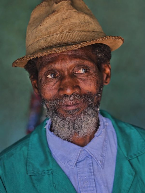 Portrait of a village chief, seated and composed, the authority of a community in one face.